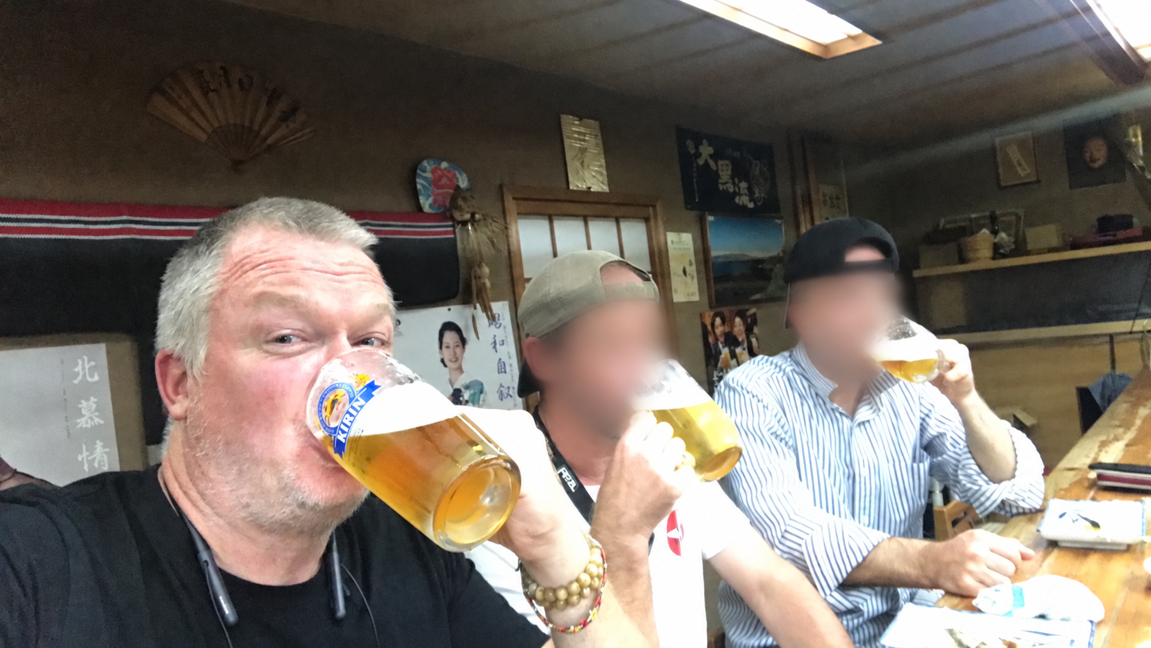 The monk and two crew members sharing evening drinks; crew faces blurred